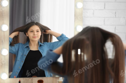Preview: Teen Looks in Mirror While Adjusting Hair
