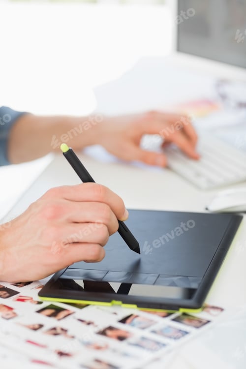 Preview: Designer working with digitizer and stylus at his desk in creative office