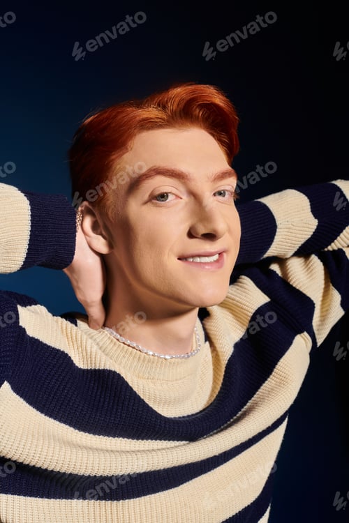 Preview: Emotional young man with striking red hair poses confidently against a dark backdrop