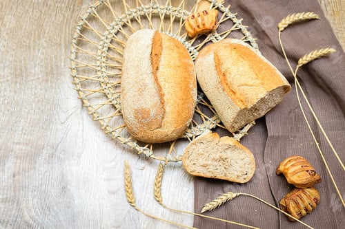 Preview: baked crisp bread sweet buns and baguette on table in basket for text, baked food concept.