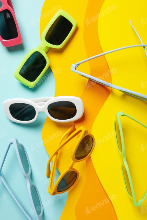 Preview: The concept of glasses on the beach, on a colored paper background