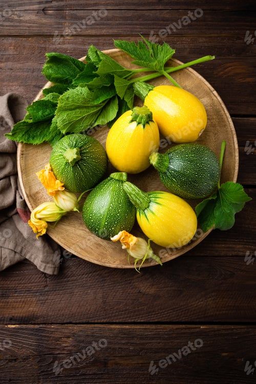 Preview: Zucchini with leaves and flowers on dark wooden rustic background