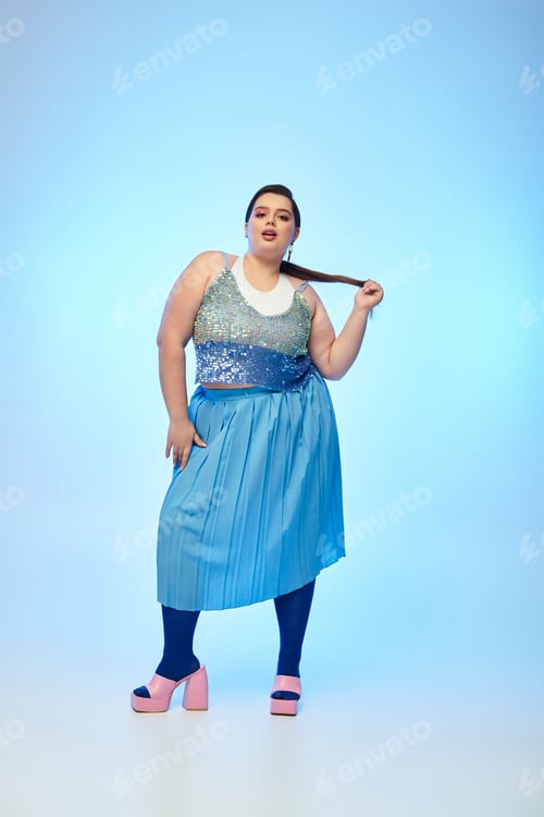 Preview: Beautiful plus size woman posing confidently in stylish outfit against a soothing blue background