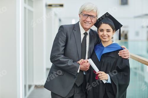 Preview: Young woman posing with professor at graduation