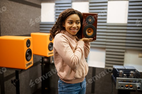 Preview: Smiling woman holds sound speaker in store