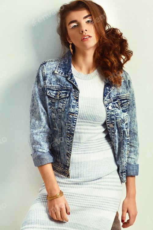 Preview: beautiful young blonde woman in nice dress and jeans jacket posing on white background in a studio.