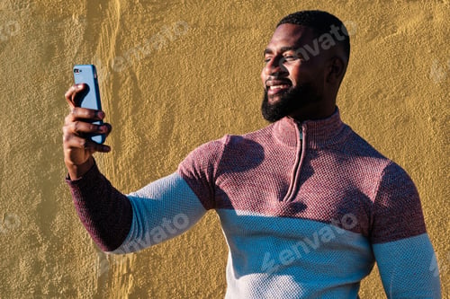 Preview: African man taking a selfie outdoors in a sunny day