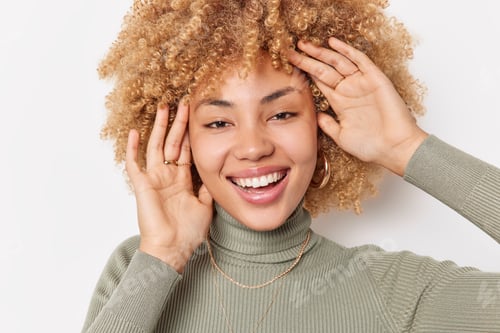 Preview: Headshot of pretty cheerful curly haired young woman has healthy skin natural beauty smiles broadly