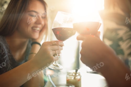 Preview: Couple clink glasses with red vine at date, celebrating anniversary or Valentine's day.