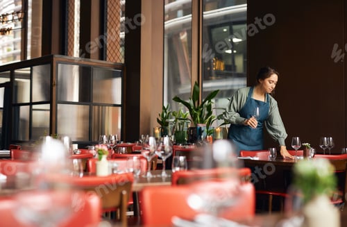 Preview: Female waitress setting tables