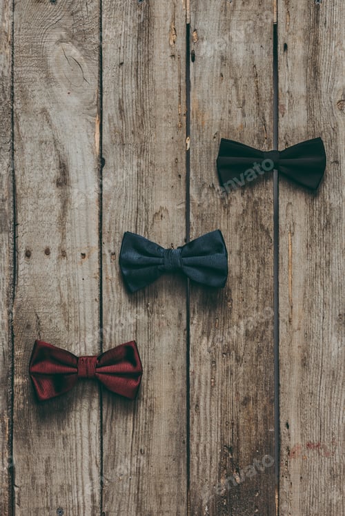 Preview: top view of classic bow ties on wooden tabletop