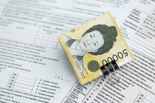 Preview: South Korean won money bills in big amount lies on table with tax forms close up