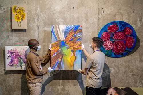 Preview: People hanging paintings for exhibition