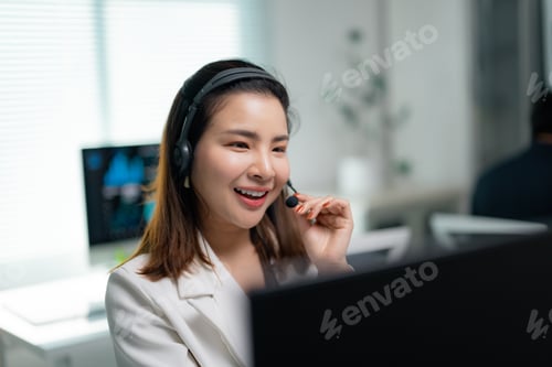 Preview: Smiling asian businesswoman telemarketer working in call center office assisting client on phone