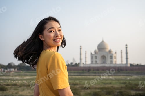 Preview: Smiling traveling woman near Taj Mahal