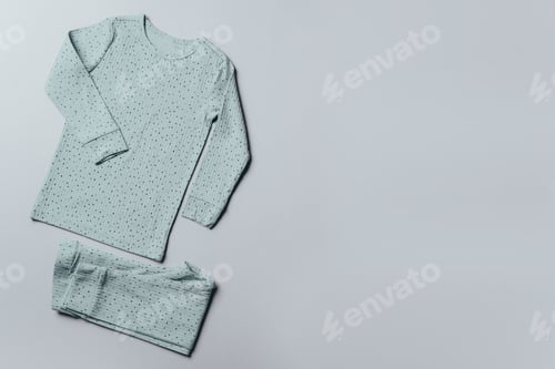 Preview: Blue pajamas for children on grey background. Pants and top for baby. Top view, copy space. Flat lay