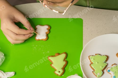 Preview: girl decorates gingerbread with sugar icing