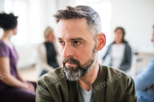 Preview: A portrait of senior depressed man during group therapy.