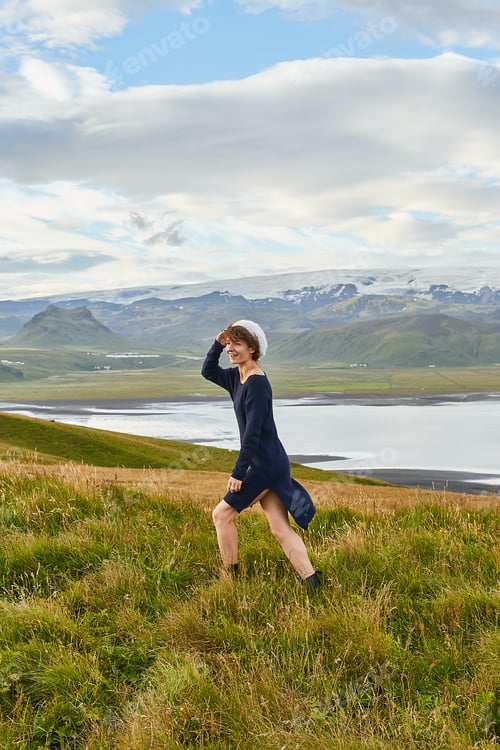 Preview: Happy young woman in dress having fun, enjoying amazing nature of Iceland in summer, standing