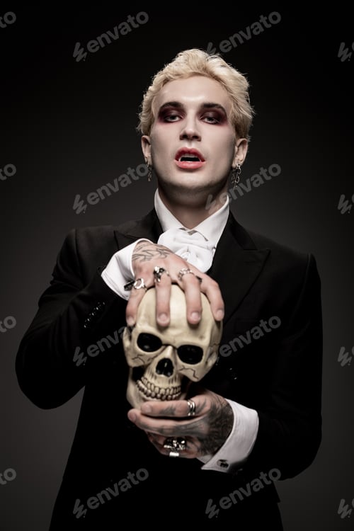 Preview: Handsome young man in an epic Halloween costume holding a skull with gothic flair