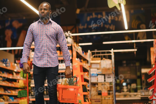 Preview: African man shopping at supermarket. Handsome guy holding shopping basket