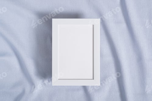 Preview: Picture frame with blank paper card mockup on blue neutral colored textile