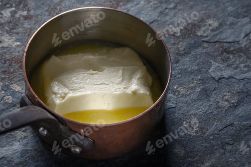 Preview: Melted butter in the stewpan on the stone background horizontal