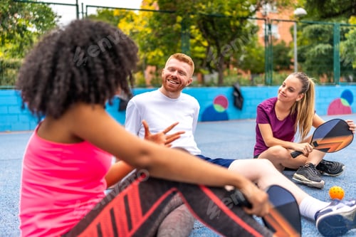 Preview: Woman talking with friends after playing pickelball in a court