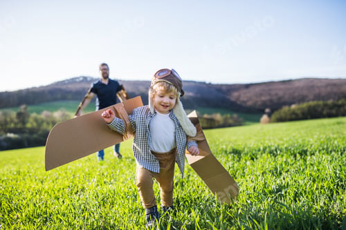 Preview: Happy toddler boy playing outside with father in spring nature.