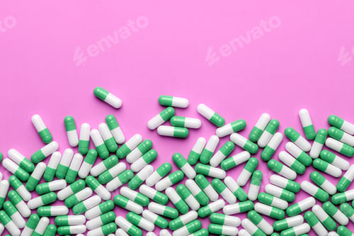 Preview: Green and white capsules form lower border on pink background with wide copy space