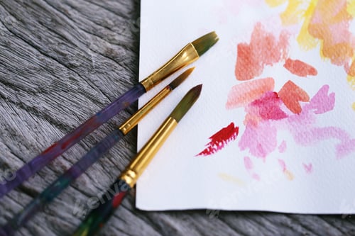 Preview: Paintbrushes and Watercolor Palette on Wooden Table