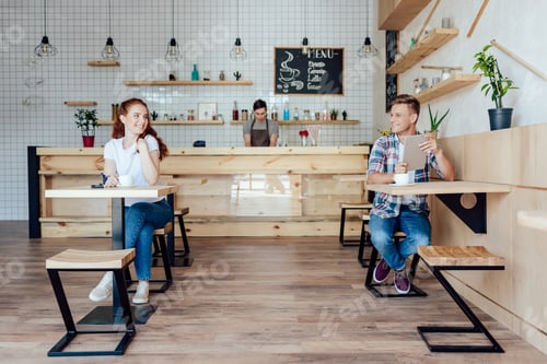 Preview: happy young man and woman smiling each other while getting to know in cafe