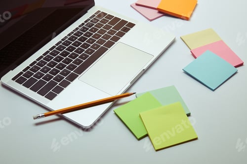 Preview: laptop, paper stickers and pencil on white tabletop
