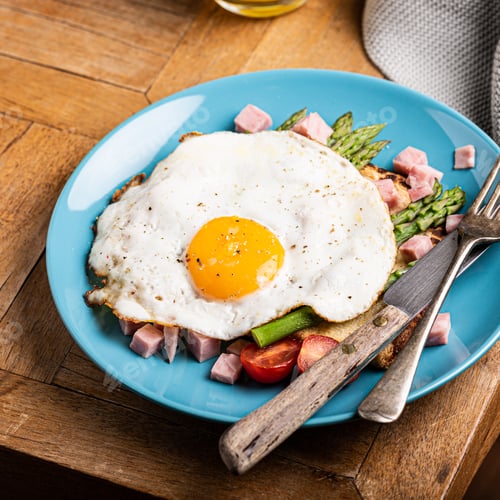 Preview: Breakfast or lunch with fried egg, bread toast, green asparagus, tomatoes and bacon