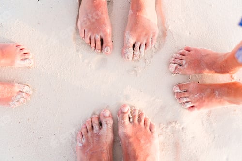 Preview: Close-up of the feet of family on the white sandy beach