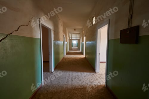 Preview: A view of a corridor in a derelict building full of sand. Vivid green coloured walls. Shadows