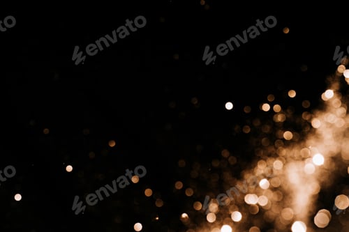 Preview: Blurred sequins of golden color on black background