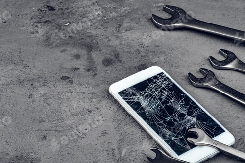 Preview: Crashed smartphone with repairing tools on grey background
