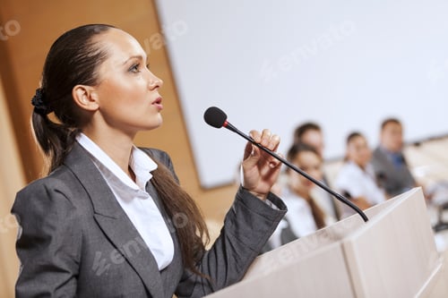Preview: Businesswoman Standing On Stage And Reporting For Audience