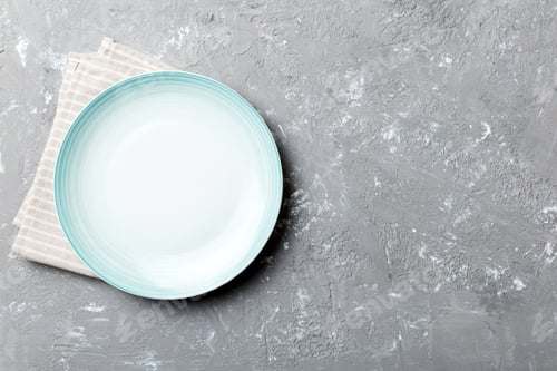 Preview: Top view on colored background empty round blue plate on tablecloth for food. Empty dish