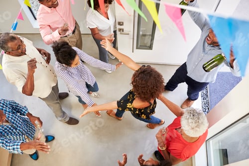 Preview: Three generation family throwing a surprise party welcoming guests at the front door,overhead view