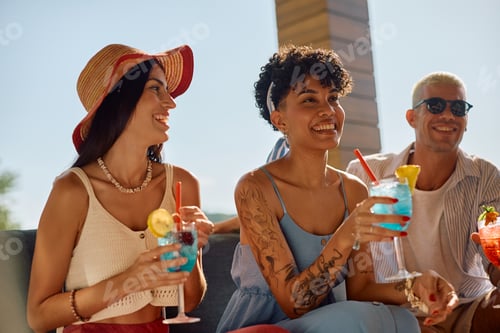 Preview: Happy black woman and her friends drinking cocktails during summer day outdoors.