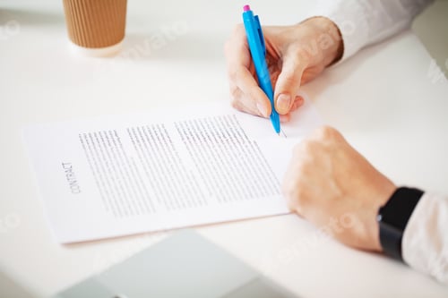 Preview: Businessman sitting at office desk signing a contract