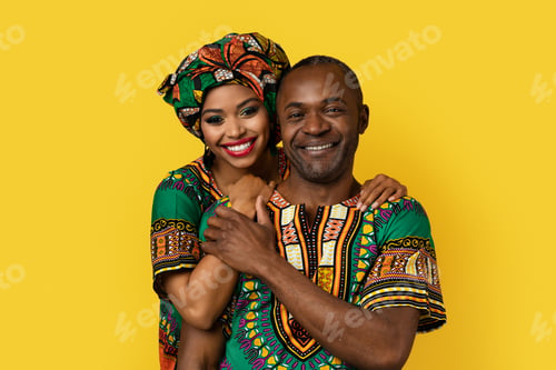 Preview: Portrait of lovely black couple in national costumes on yellow
