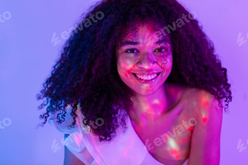 Preview: Attractive happy African woman in white suit is sitting and smiling in studio