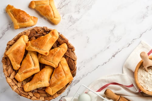 Preview: Fried empanadas with cilantro, meat, egg, tomato and chili sauce on white background. Latin American