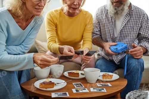 Preview: Friends viewing photos over tea