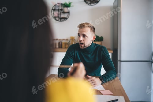 Preview: Serious man talking to colleague in kitchen