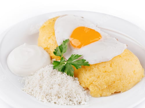 Preview: Delicious and healthy polenta with cheese, sour cream and fried egg on white plate