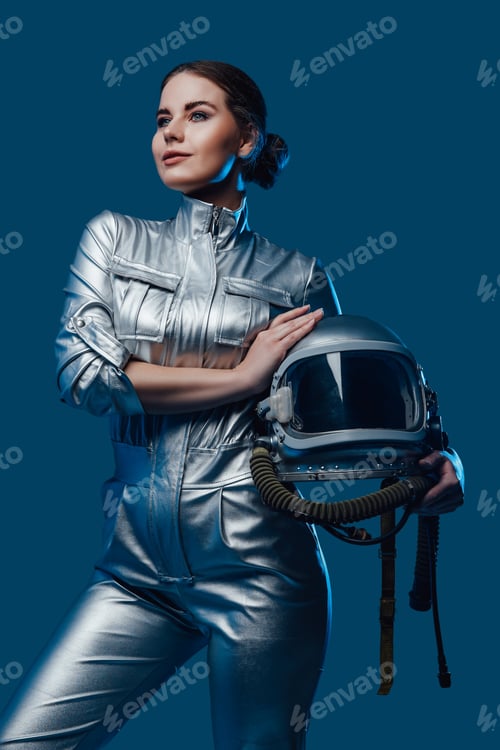 Preview: Woman in Futuristic Silver Suit Holds Astronaut Helmet